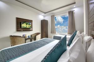新德里Hotel Devrana Delhi的一间卧室设有一张大床和一个窗户。