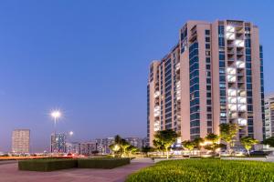 迪拜迪拜兰德阿拜德斯公寓酒店的一座高大的建筑,以城市天际线为背景