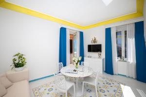 波西塔诺弗拉维奥焦亚别墅酒店的蓝色和白色的客厅配有桌椅