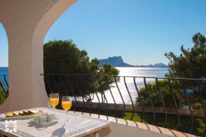 莫莱拉Villa Dauphin by Abahana Villas的阳台上的桌子和两杯葡萄酒