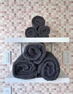 宇都宫Maria Hotel 宇都宮的浴室架子上的一大堆毛巾