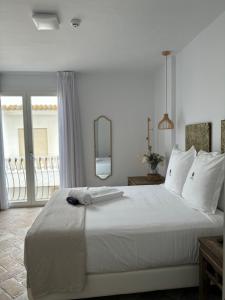 萨阿拉德洛斯阿图内斯Casapuerta El Refugio的卧室配有一张大白色床和窗户