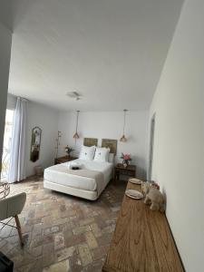 萨阿拉德洛斯阿图内斯Casapuerta El Refugio的卧室配有白色的床和木桌