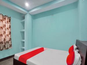 巴特那OYO Flagship New Pushpanjali Guest House的一间卧室设有蓝色的墙壁和一张红色的床。