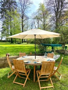 Prez-sous-LafaucheGrande et belle demeure的草上带雨伞的桌子