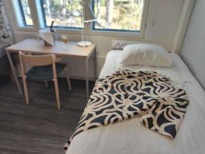 图尔库Hotel Linnasmäki的客房设有一张床、一张书桌和一张书桌。