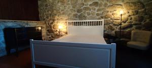 布拉加Casa das Oliveiras的石墙房间内的一张床位
