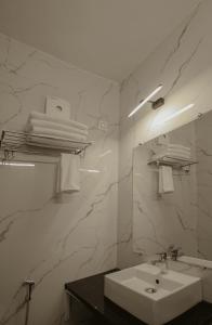 哈里瓦Arjun - A boutique hotel的白色的浴室设有水槽和镜子