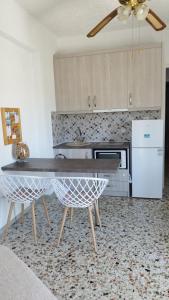 波多河丽Angelique Όμορφο διαμέρισμα στο Porto Heli的厨房配有桌子和两把椅子