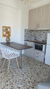 波多河丽Angelique Όμορφο διαμέρισμα στο Porto Heli的厨房配有桌子和台面