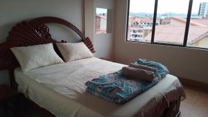 苏克雷Posada de Mary的一间卧室设有一张大床和大窗户