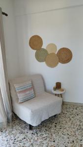 波多河丽Angelique Όμορφο διαμέρισμα στο Porto Heli的客厅配有椅子和白色墙壁