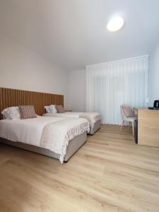 梅阿利亚达NR Suites的一间卧室设有两张床,铺有木地板