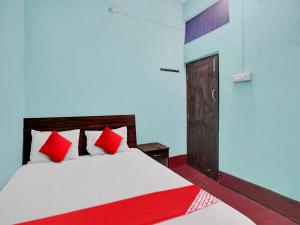 巴特那OYO Flagship New Pushpanjali Guest House的一间卧室配有红色枕头的床