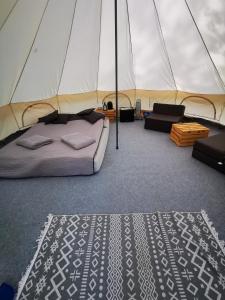 沃胡夫Glamping Kaliska的帐篷内的卧室,配有一张床和地毯