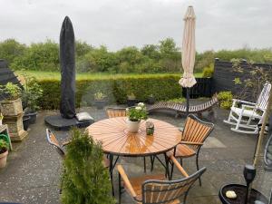 奈斯特韦兹Velindrettet rækkehus med fantastisk udsigt的庭院配有桌椅和遮阳伞。