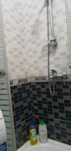 斯库台City Center Apartment的浴室铺有黑白瓷砖,设有淋浴。