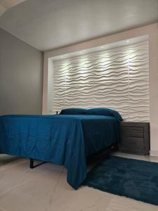 马亚圭斯Nala's Studio的一间卧室设有蓝色的床和窗户。