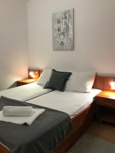 诺瓦利娅Apartmani Samec的一间卧室设有两张床和两个床头柜