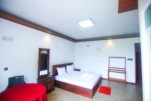 DankotuwaTharidu Hotel Dankotuwa的一间卧室配有一张床、镜子和椅子