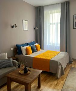 利沃夫Fiesta Apartment on Franka 2BR-6P的一间卧室配有一张大床和一张沙发