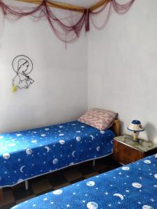 萨维勒特里appartamenti del pescatore的一间卧室配有两张带蓝色床单的床和一张桌子