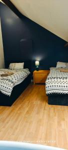 莱斯特St Lucia lodge Leicester long stays available的配有蓝色墙壁和木地板的客房中的两张床