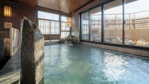 盛冈Dormy Inn Morioka的一座大型游泳池,位于一座带窗户的建筑内