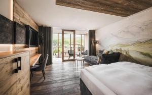 圣维吉利奥Excelsior Dolomites Life Resort的酒店客房设有床和客厅。