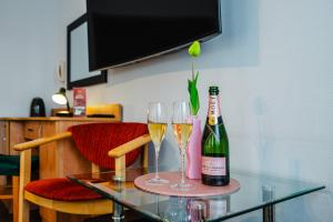 凯尔采布里斯托尔酒店 的一张桌子,上面放有两杯葡萄酒和一瓶香槟