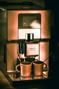 Saint-Martin-des-Entrées"l'Escape room" - love room atypique的架子上带两个咖啡杯的咖啡机