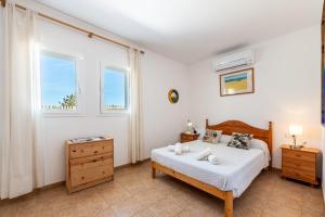 卡拉索纳Casa Es Vedrà的一间卧室设有一张床和两个窗户。