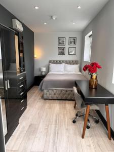 PinnerLetzi Private En-Suite In Harrow的一间卧室配有一张床、一张书桌和一张书桌