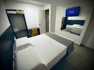 累西腓Sun Smart Hotel -的卧室配有一张白色大床和镜子
