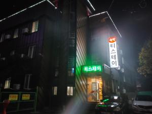清州市T stay guesthouse的一座建筑物,晚上在建筑物的一侧有标志