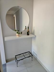 圣特雷莎casa/apartamento centro Santa Teresa-ES的浴室设有镜子和1个带1瓶葡萄酒的架子