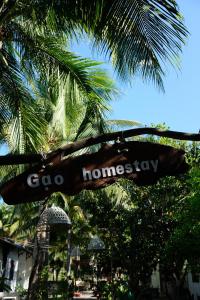 美奈Gạo Homestay的挂在棕榈树上的goo回乡的标志