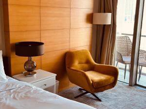 迪拜Emaar Fashion avenue-Formerly Address Dubai Mall Residence的卧室配有床边的椅子