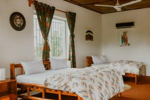 达累斯萨拉姆Perfect Beach House In Kigamboni的带窗户的客房内设有两张单人床。