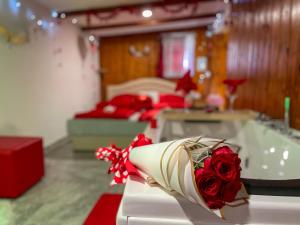科雷尼察Holiday Home La Sierra的客房设有两张床和一张带一束玫瑰花的桌子。