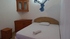 DankotuwaTharindu Hostel的卧室配有白色的床和木制橱柜。