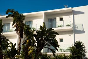 埃斯卡纳玛瓦韦尔塔旅馆的一座白色的建筑,前面有棕榈树