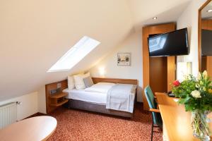 不莱梅Hotel Garden Bremen的配有一张床和一台平面电视的酒店客房