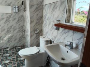 莫阿尔博阿Sambag Hideaway Bungalows的浴室配有白色卫生间和盥洗盆。