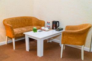 巴库Sahil Ark Hotel Baku的一张带两把椅子的茶几和一张沙发