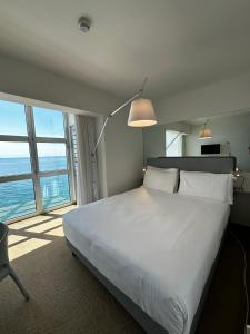 的里雅斯特Hotel Miramare - Adults Only的一间卧室设有一张大床和一个大窗户