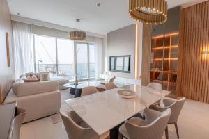 迪拜Avani Plus Palm View Dubai Suites的客厅配有玻璃桌和椅子
