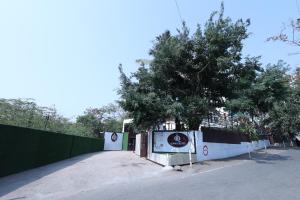 孟买Quaint Suites Hotel & Banquet的道路一侧有树的栅栏