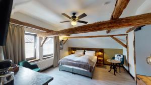 巴特贝勒堡希彻勒阿尔特酒店的一间卧室配有一张床和吊扇