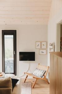 伊皮Knus I Tiny house op de Veluwe的客厅配有椅子和电视